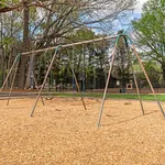 Inviting playground swings set amidst lush greenery, perfect for family enjoyment and outdoor fun.