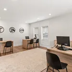 Modern and bright office space featuring sleek wooden desks, comfortable black chairs, and elegant wall decor, perfect for a productive work environment.
