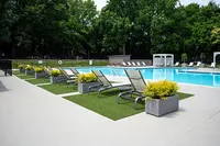 Luxurious swimming pool area with stylish loungers and lush greenery, perfect for relaxation and leisure.