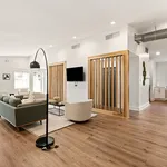 Modern apartment living room with sleek wooden flooring, stylish furniture, and bright natural lighting offering a welcoming ambiance.