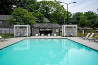 Inviting outdoor pool area surrounded by lush greenery and comfortable lounge chairs, perfect for relaxation and leisure.