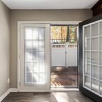 Bright and inviting interior view featuring French doors opening to a private outdoor space, offering natural light and seamless indoor-outdoor living.