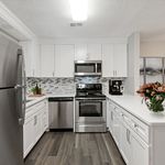 Modern kitchen with sleek stainless steel appliances, stylish white cabinetry, and elegant gray backsplash.
