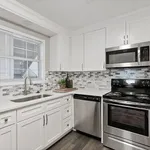 Contemporary kitchen boasting sleek stainless steel appliances, elegant white cabinetry, and a modern mosaic backsplash.