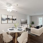 Modern open-concept living and dining area with elegant decor, featuring a stylish round dining table set, cozy seating, and vibrant artwork.