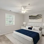 Inviting bedroom with plush bed, modern artwork, and natural light, perfect for relaxation and rest.