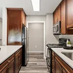 Elegant kitchen with sleek stainless steel appliances, polished wooden cabinetry, and contemporary lighting.