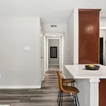 Modern apartment hallway with sleek wood flooring and a cozy breakfast bar, radiating contemporary elegance.