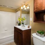 Elegant bathroom with dark wood vanity, sleek white fixtures, and vibrant floral accents for a fresh touch.