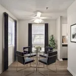 Bright dining area with elegant glass table, modern chairs, and natural light streaming through large windows.