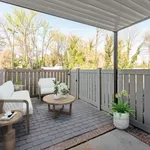 Inviting outdoor patio featuring elegant wicker furniture, lush greenery, and a cozy atmosphere perfect for relaxation.