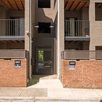 Modern apartment entrance with sleek balconies and stylish brick facade.