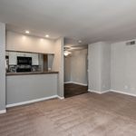 Inviting open living space with modern kitchen, warm carpeted floors, and ambient lighting.
