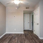 Bright, modern interior with sleek wood flooring, neutral walls, and a ceiling fan, featuring white doors leading to adjacent rooms.