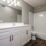 Modern bathroom with sleek white cabinetry, elegant lighting, and a stylish bathtub for a luxurious feel.
