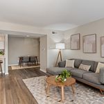 Elegant living room with modern gray sofa, chic wooden coffee table, and inviting open dining area.