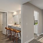 Chic apartment interior with a modern kitchen island, stylish bar stools, and elegant lighting.