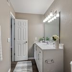 Elegant bathroom design with a sleek vanity, large mirror, and modern lighting, offering a serene and refreshing atmosphere.