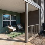 Charming covered patio with two elegant wicker chairs, perfect for relaxing and enjoying the outdoors.