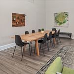 Elegant dining room with modern wood table, stylish black chairs, and tasteful wall art creating a cozy, inviting atmosphere.