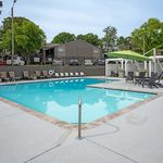 Inviting outdoor pool area with stylish lounge chairs, shaded seating, and lush greenery providing a serene retreat.