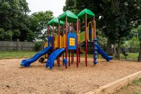 Vibrant playground featuring colorful slides and climbing structures in a lush green park setting, perfect for outdoor family fun.