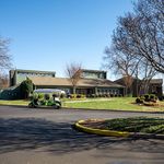 Charming residential community with lush greenery, modern architecture, and a convenient golf cart, perfect for comfortable living.