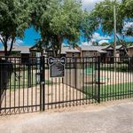 Charming pet-friendly Bark Park with bright play equipment and lush green surroundings, nestled in a cozy residential area.