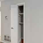 Bright and modern closet space with white door and built-in shelving offering ample storage solutions.