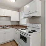 Bright and modern kitchen with white cabinets, sleek countertops, and a cozy layout, perfect for home cooking.