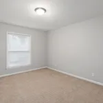 Bright and inviting room with soft carpet flooring, fresh gray walls, and ample natural light through a large window, perfect for a peaceful retreat.