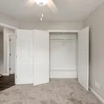 Bright and inviting bedroom with plush carpet, spacious closet, and modern ceiling fan for ultimate comfort.