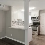 Modern apartment kitchen with sleek white cabinets, stylish backsplash, and stainless steel appliances.