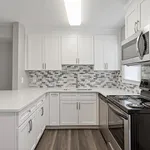 Bright and modern kitchen with sleek white cabinetry, stylish mosaic backsplash, and stainless steel appliances.