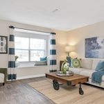 Bright, cozy living room with stylish decor, featuring a large window nook, striped curtains, and a chic coffee table on elegant wooden flooring.