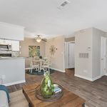 Bright and inviting open-concept living area with a modern kitchen, cozy dining space, and elegant hardwood floors.