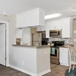 Elegant kitchen with modern appliances, sleek white cabinets, and a cozy breakfast bar.