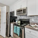 Modern kitchen with sleek stainless steel appliances, elegant white cabinetry, and a stylish tiled backsplash.