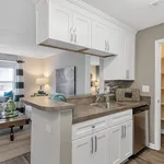 Chic open kitchen with modern cabinetry, stainless steel appliances, and inviting living room view.