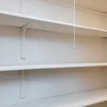 Spacious built-in shelving unit in a bright room with a pull string light, perfect for stylish storage solutions.