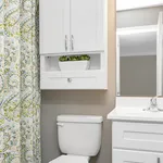Chic bathroom design with modern white cabinets, elegant countertop, and decorative shower curtain adding a vibrant touch.