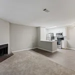 Modern open-concept living space with cozy fireplace, stylish kitchen with stainless steel appliances, and elegant flooring.