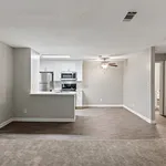 Contemporary open-plan living room with sleek kitchen, stainless steel appliances, and elegant wood floors.