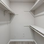 Spacious walk-in closet with built-in shelving and hanging rods, offering ample storage and organization options.