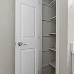 Elegant white closet with built-in shelves, perfect for organized storage solutions.