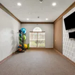 Modern fitness room featuring sleek exercise equipment and a stylish wall-mounted TV, ideal for a dynamic home workout experience.