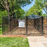 Charming dog park with secure fencing set amidst lush green trees, perfect for pet enjoyment.