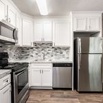 Modern kitchen with sleek stainless steel appliances, elegant white cabinetry, and a stylish tile backsplash.
