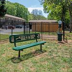 Inviting dog park with a charming green bench and scenic views, perfect for pet-friendly living.