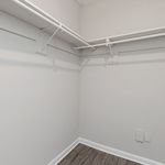 Expansive walk-in closet with ample shelving and modern design, perfect for organized living.